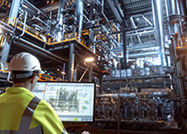 Technician reviewing inspection data on a monitor inside an industrial facility